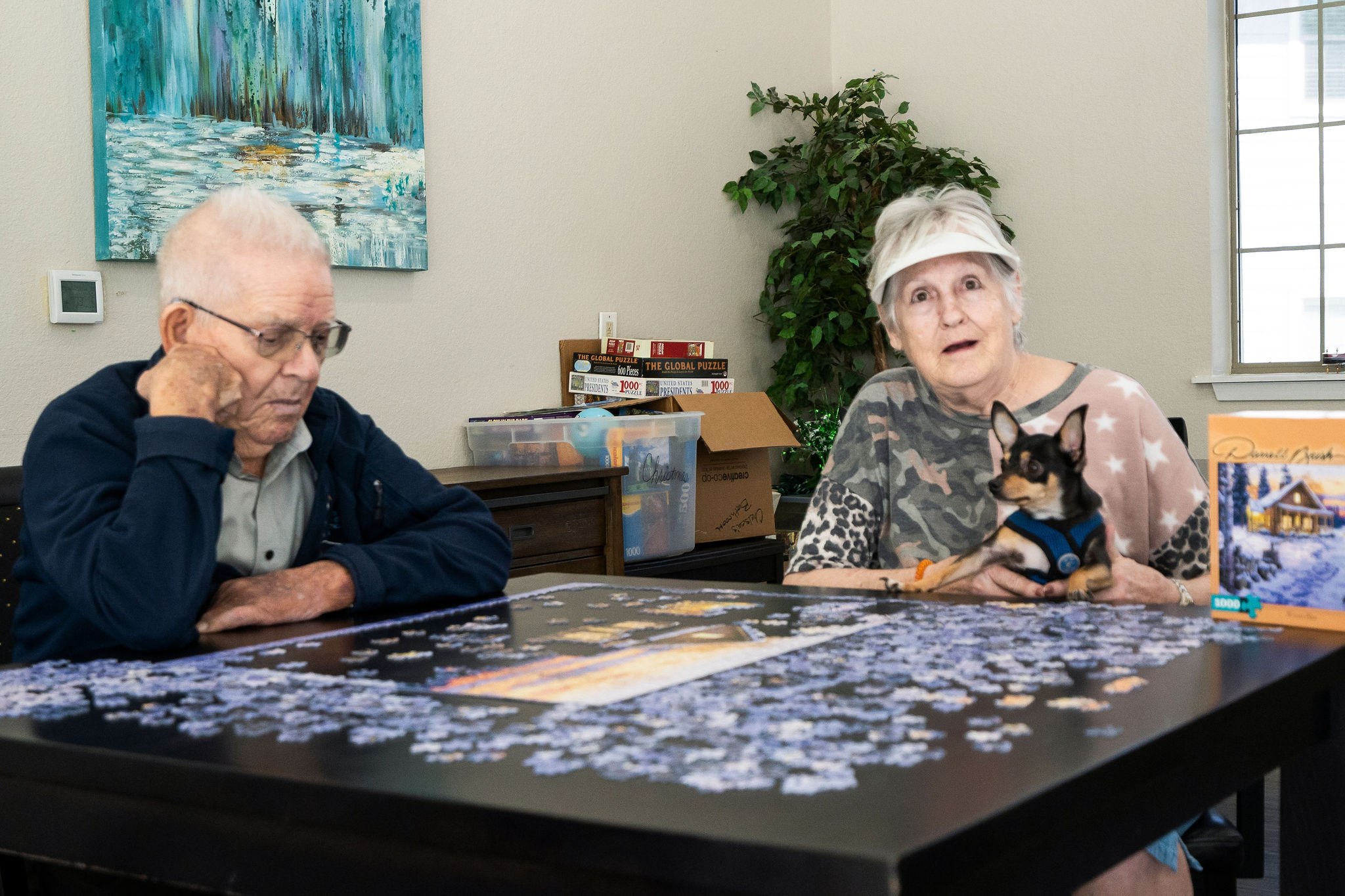 Two residents of Sundale Senior Living in Huntsville, TX, completing a puzzle together