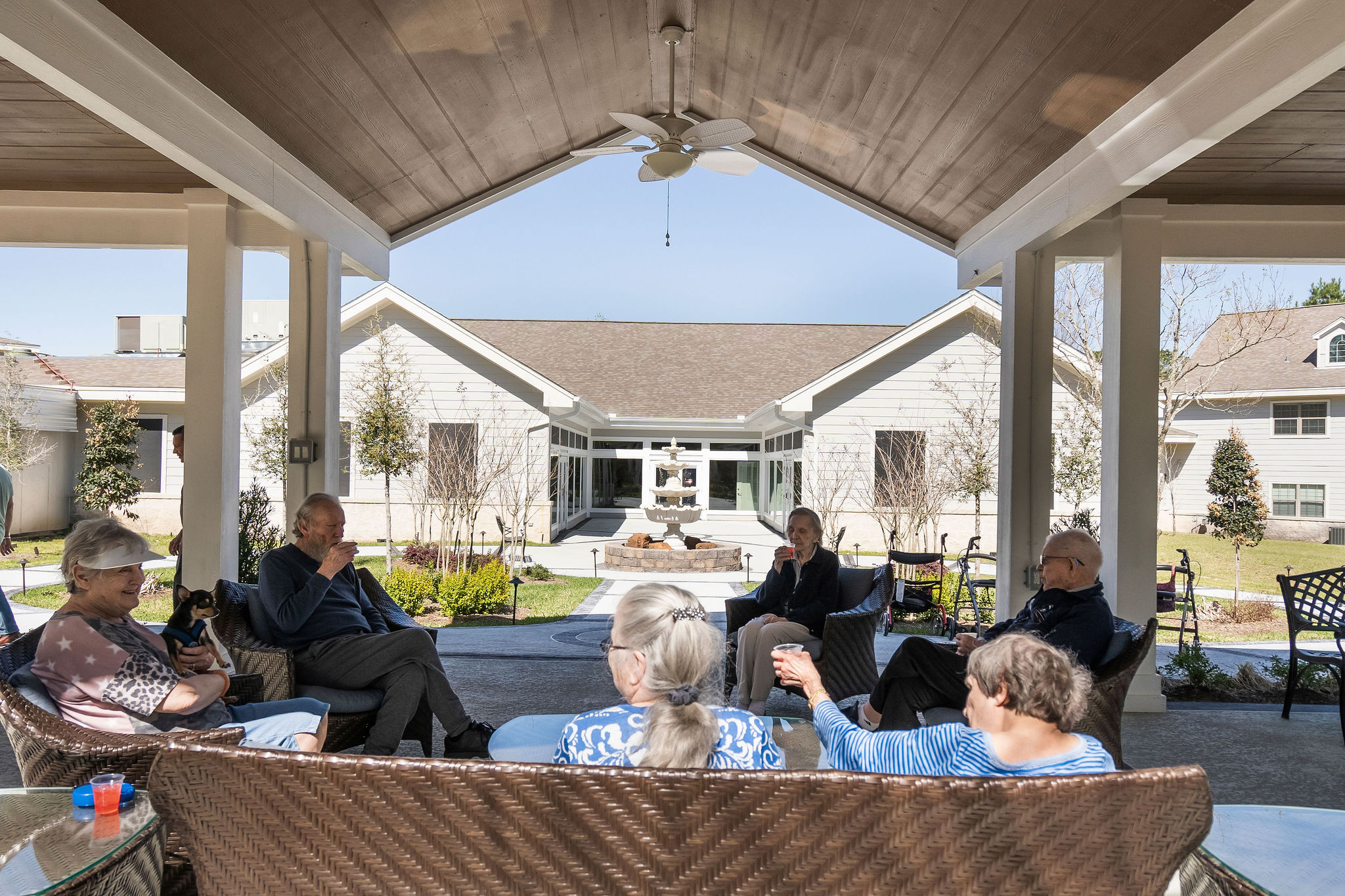 a group of older adults socializing outside at a senior living community