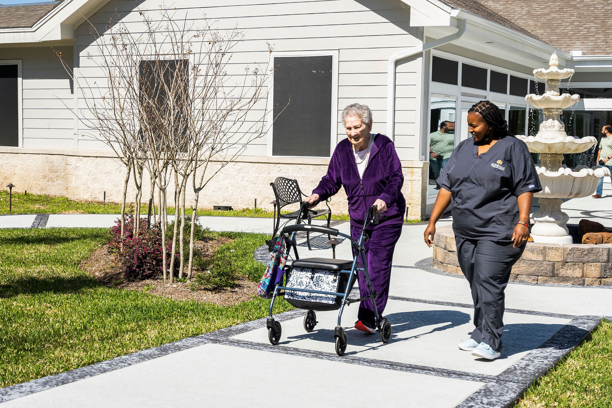senior woman and community staff member taking a midday outdoor walk