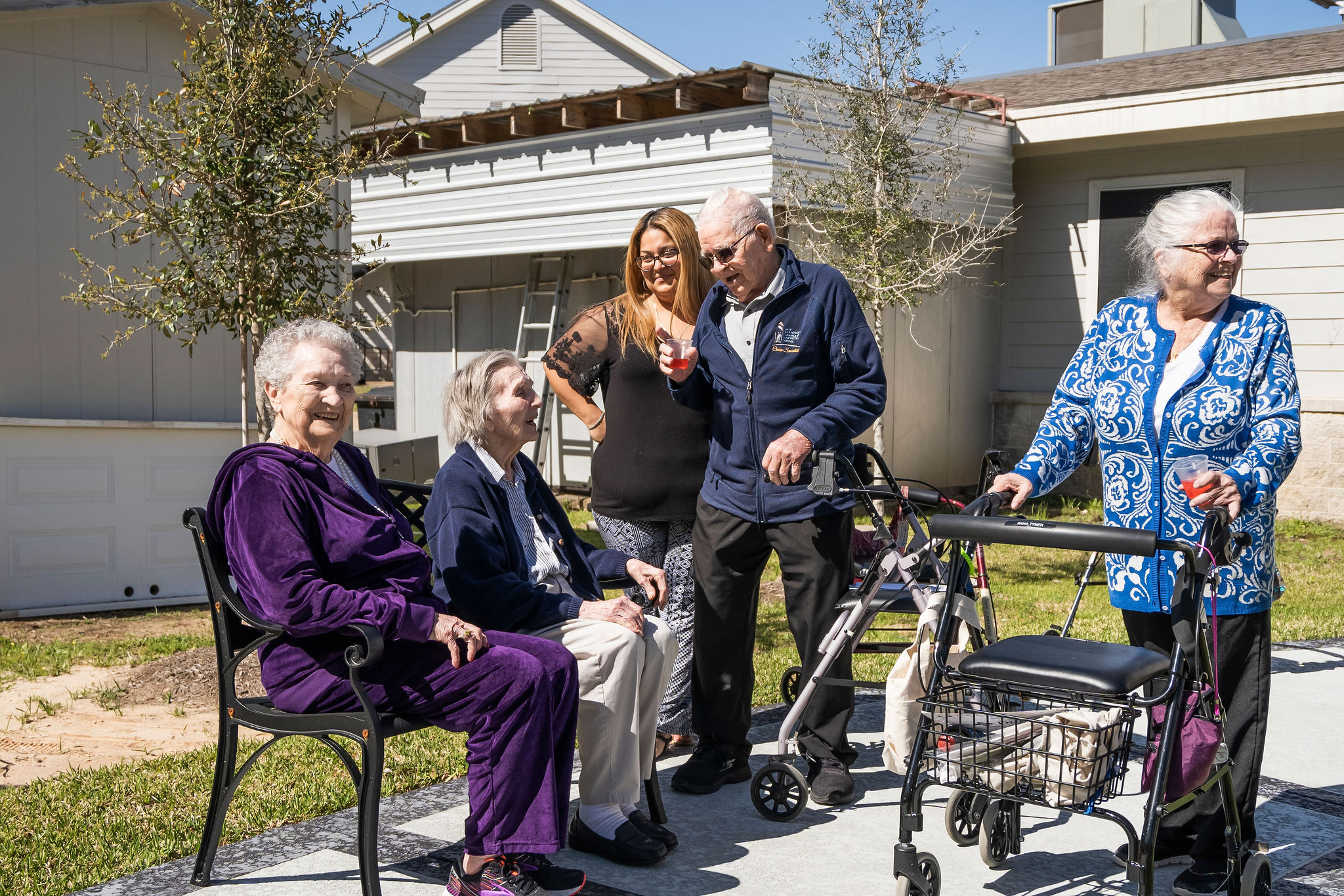 Assisted living residents and staff members of Sundale Senior Living socialize outside