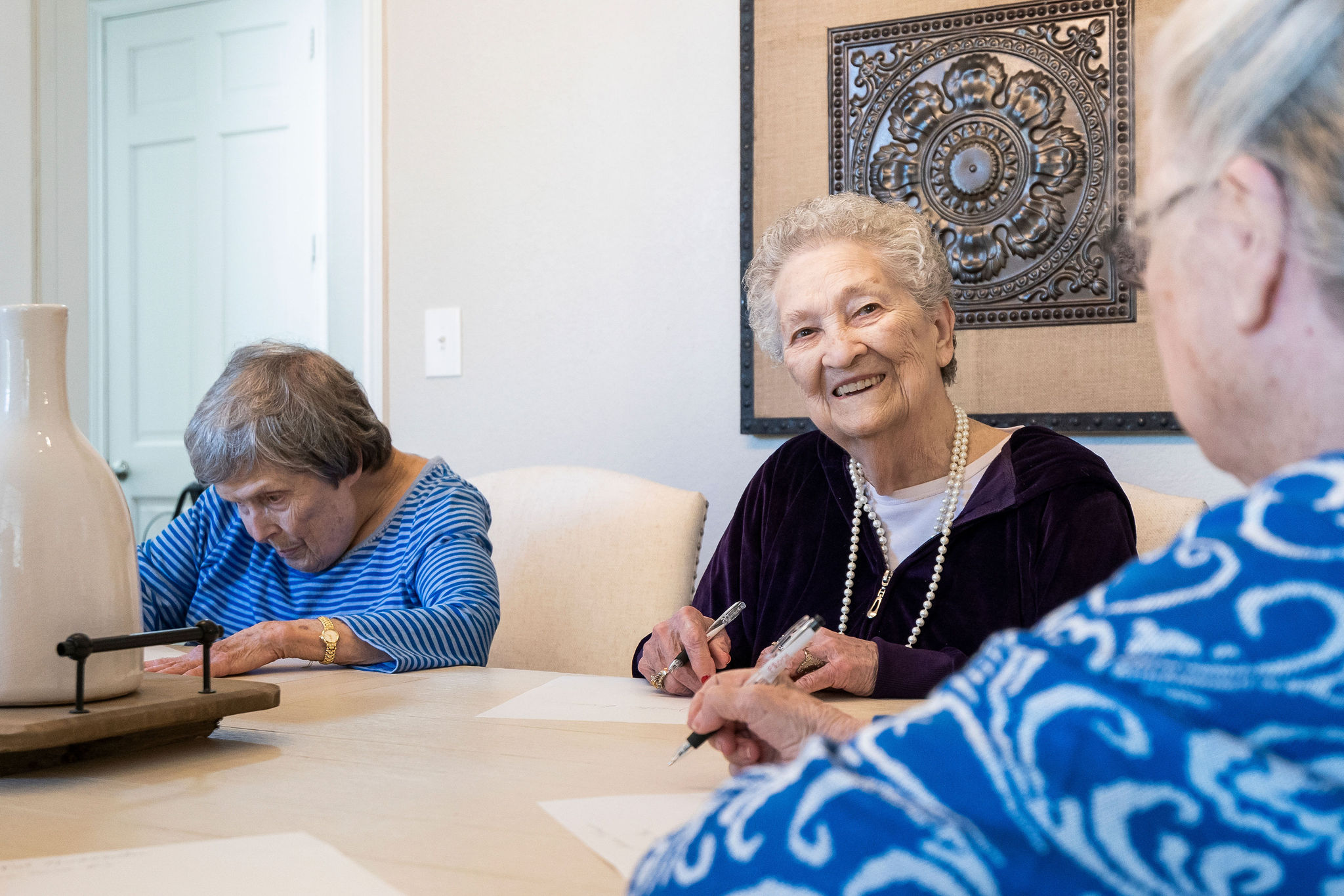 An older woman smiling as she plays a game at Sundale Senior Living in Huntsville, TX