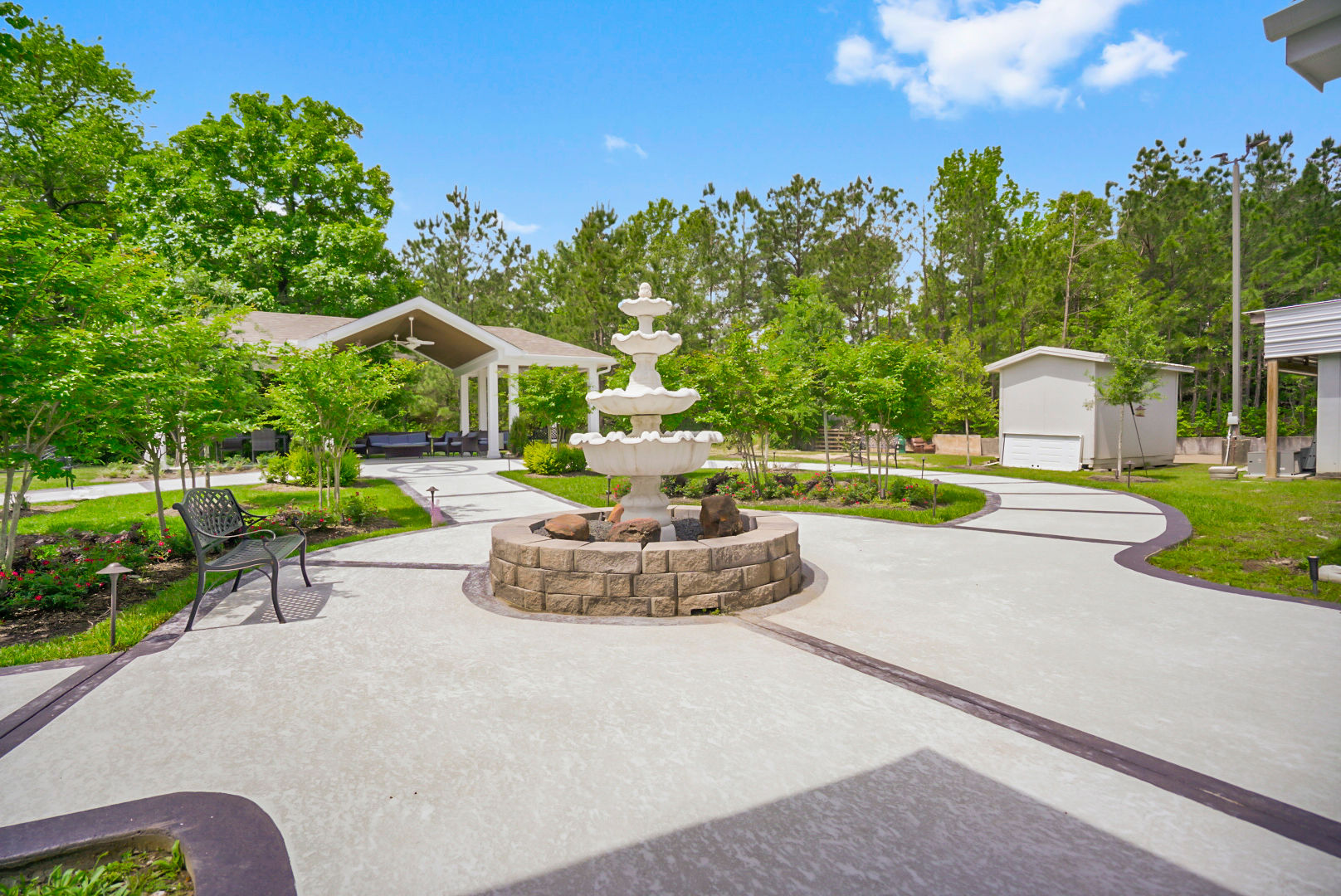 The highly maintained courtyard area at Sundale Senior Living in Huntsville, TX, featuring a fountain, walking paths, and gazebo