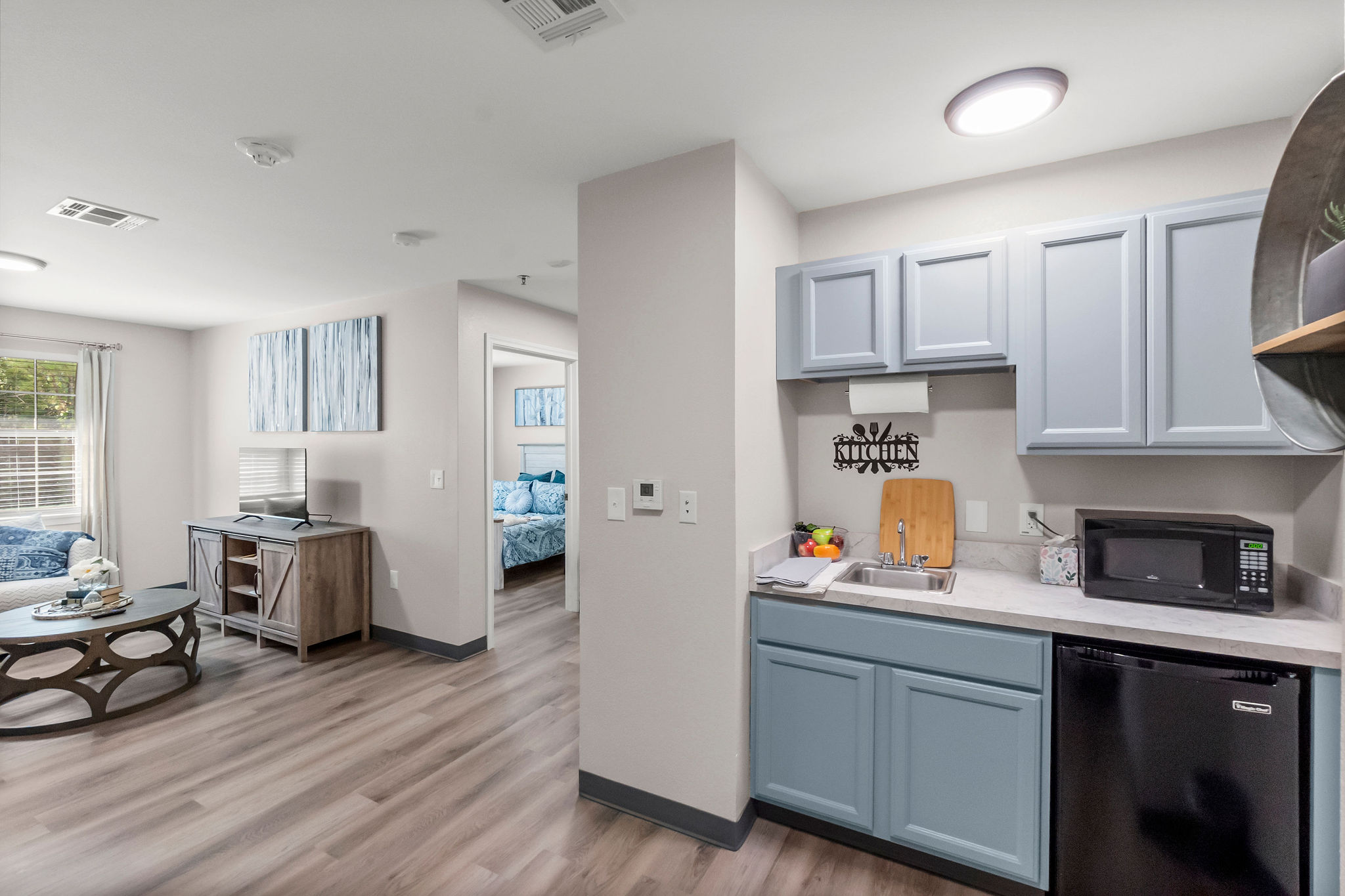 An apartment living area and kitchen at Sundale Senior Living in Huntsville, TX